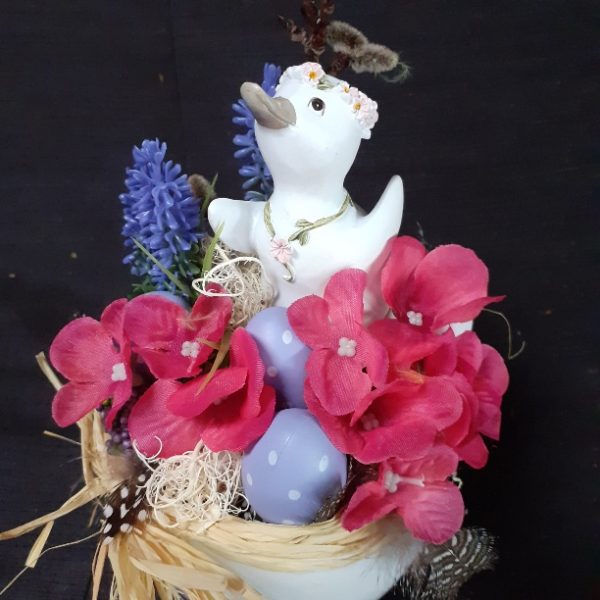 Eendje tussen bloemen in paasei